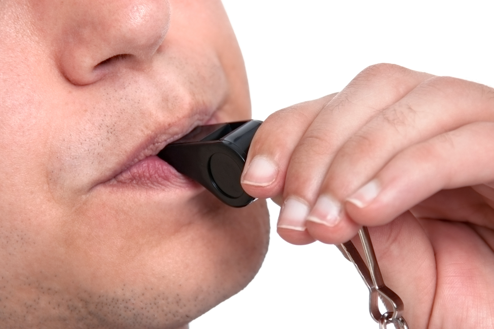 person blowing a whistle