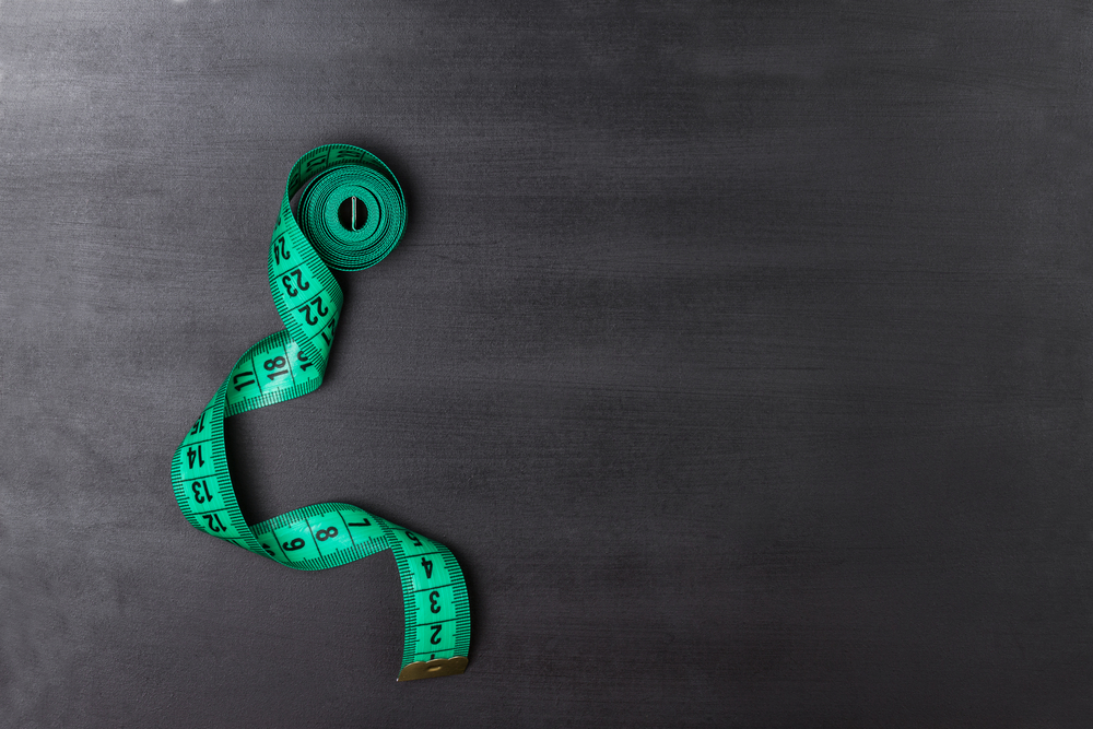 Measuring tape on a slate background