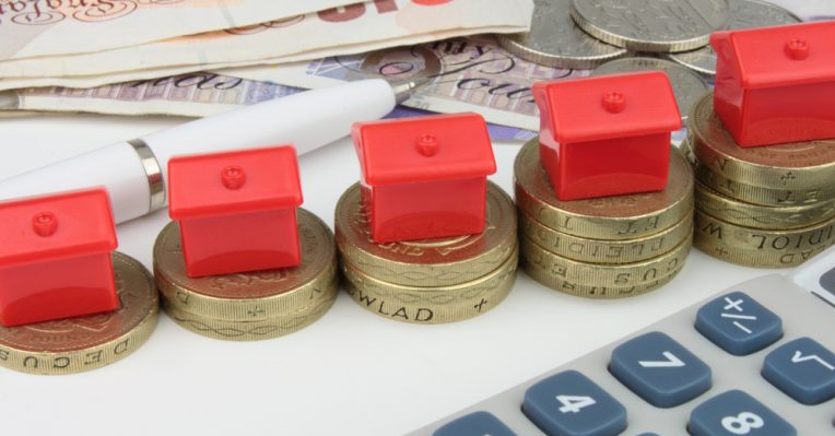 little houses on pound coins next to a calculator