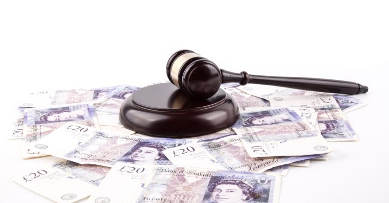 an image of a gavel on bank notes to denote a story about mortgage fraud
