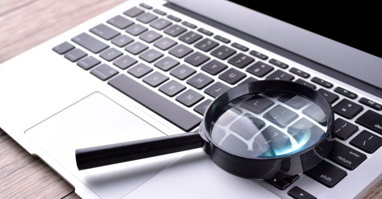 an image of a magnifying glass on a computer keyboard to denote a story about Moneyfacts' market information tool