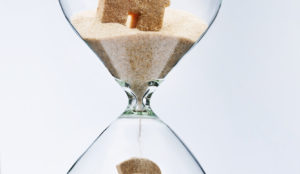 an image of a sand timer with a house and question mark inside to denote a story about lifetime mortgage advances