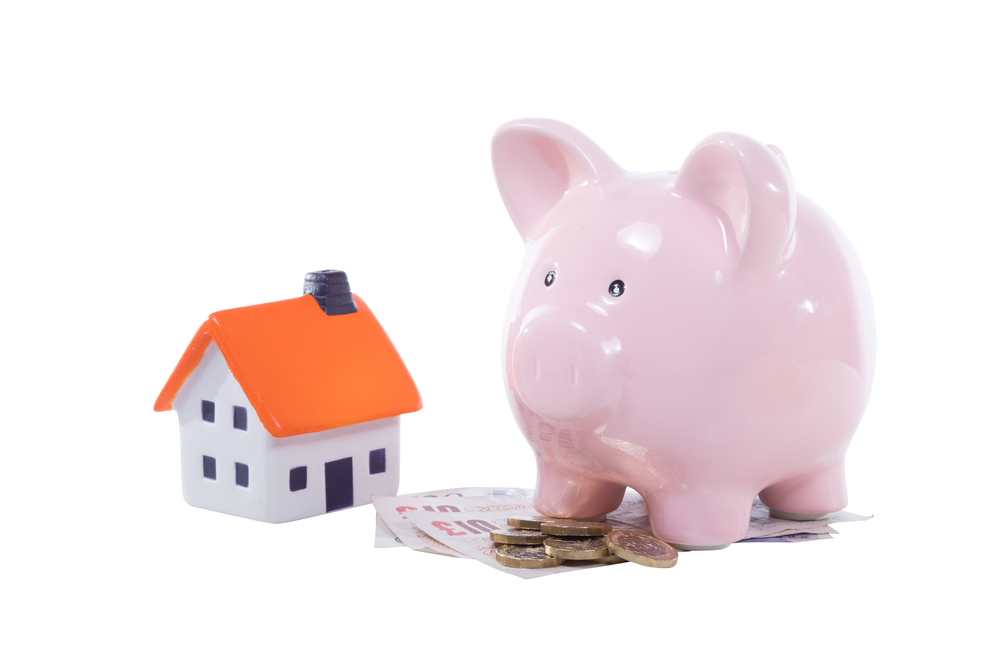 Piggy bank and house to denote adverse credit