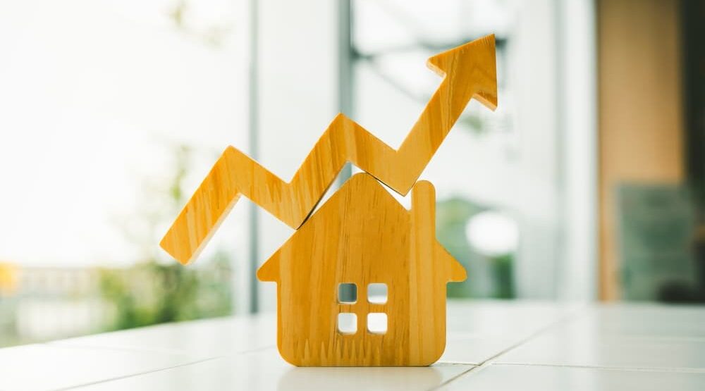 a wooden arrow zigzagging upwards on top of a small wooden house icon to denote LendInvest's mortgage lending results